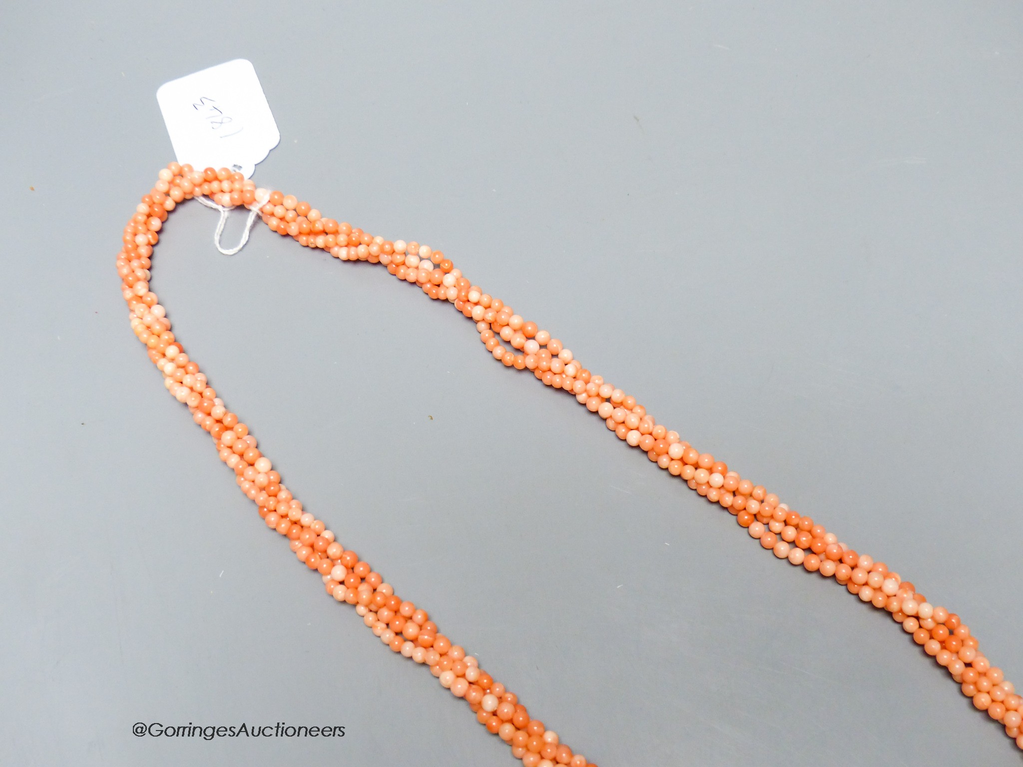 A modern twisted quadruple strand coral bead necklace, 78cm.